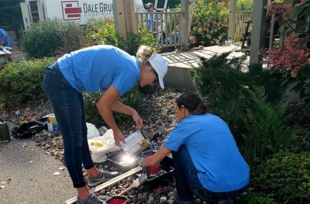 2 volunteers doing outdoor cleanup