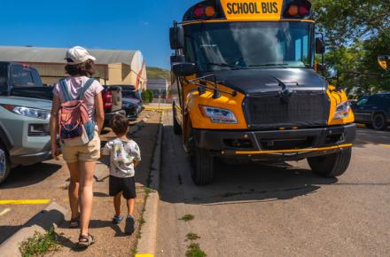 Parent walking child to a school bus