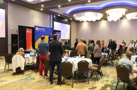 Group of people standing in a ballroom