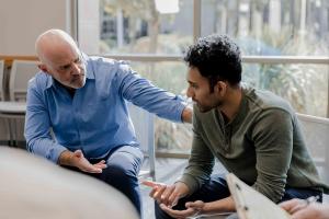 Two adult males in conversation